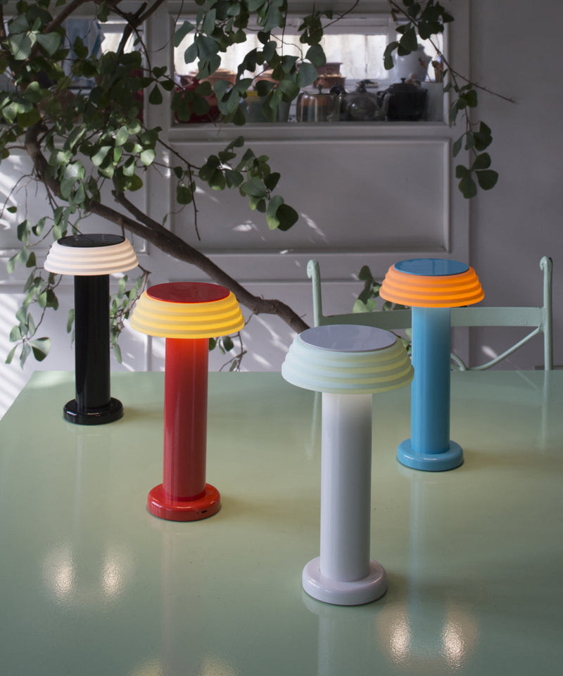 A collection of the Sowden PL1 portable lamps in a range of colours on a table