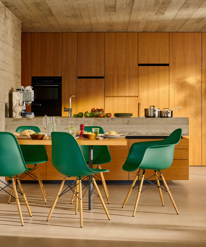 Vitra Eames DSW plastic side chair with a green shell and wooden legs